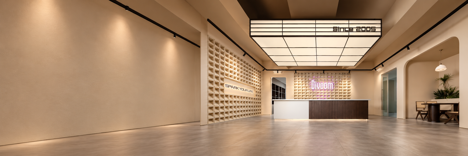 Warm beige Divoom reception with illuminated ceiling and a wood front desk