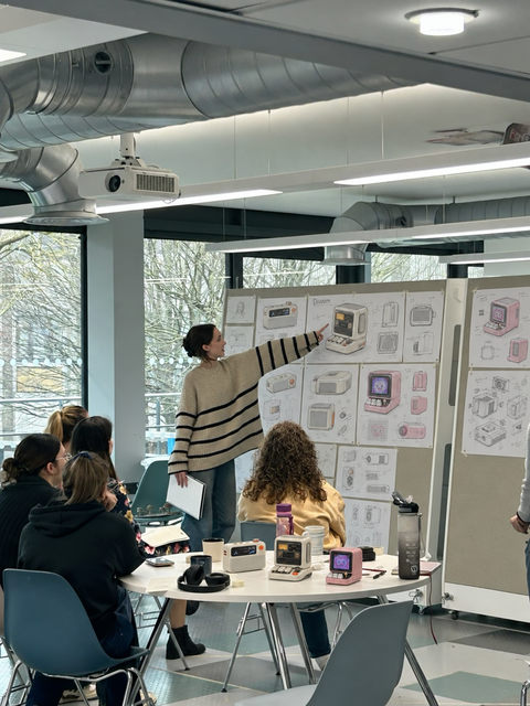 Team discussing Divoom product designs with devices and sketches